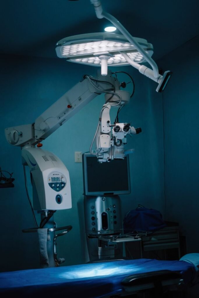 Surgical operating room with advanced medical equipment and blue lighting.
